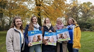 Fünf Frauen stehen auf einem grünen Rasen. Sie schauen in die Kamera und halten eine Tasche in der Hand. Auf der Tasche ist ein Foto von einem Baby mit einem Teddybär zu sehen. © Landkreis Rotenburg (Wümme)